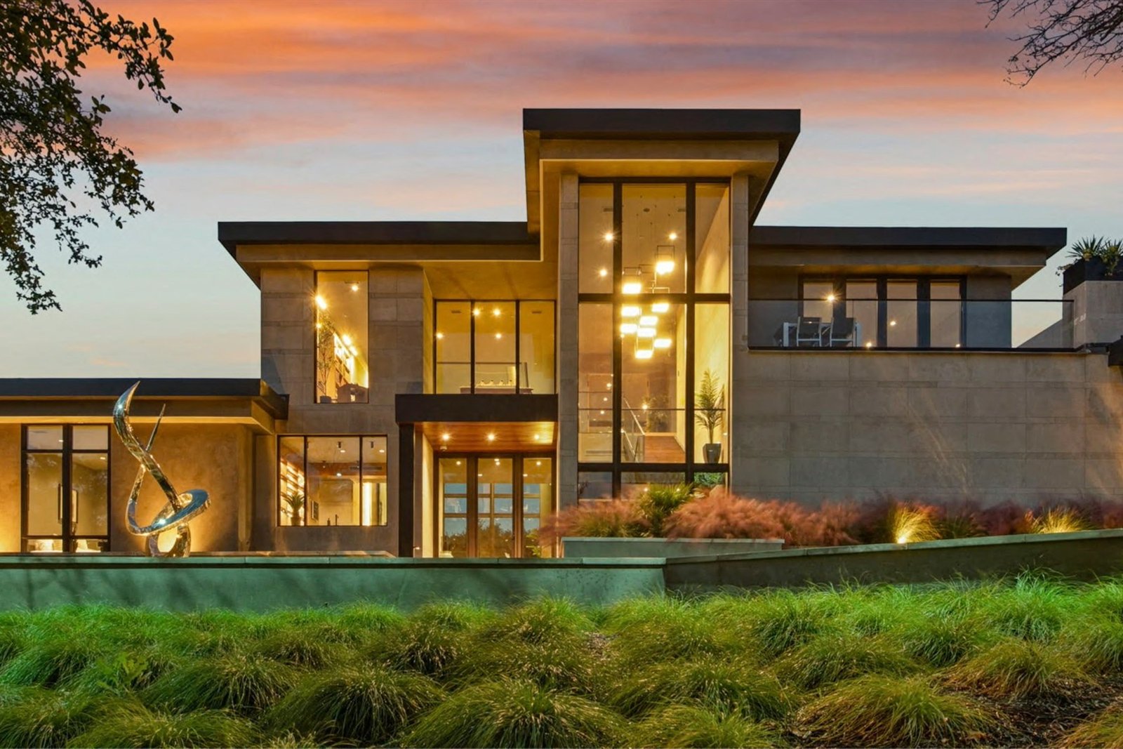 Modern facade at dusk with interiors glowing warmly through large windows